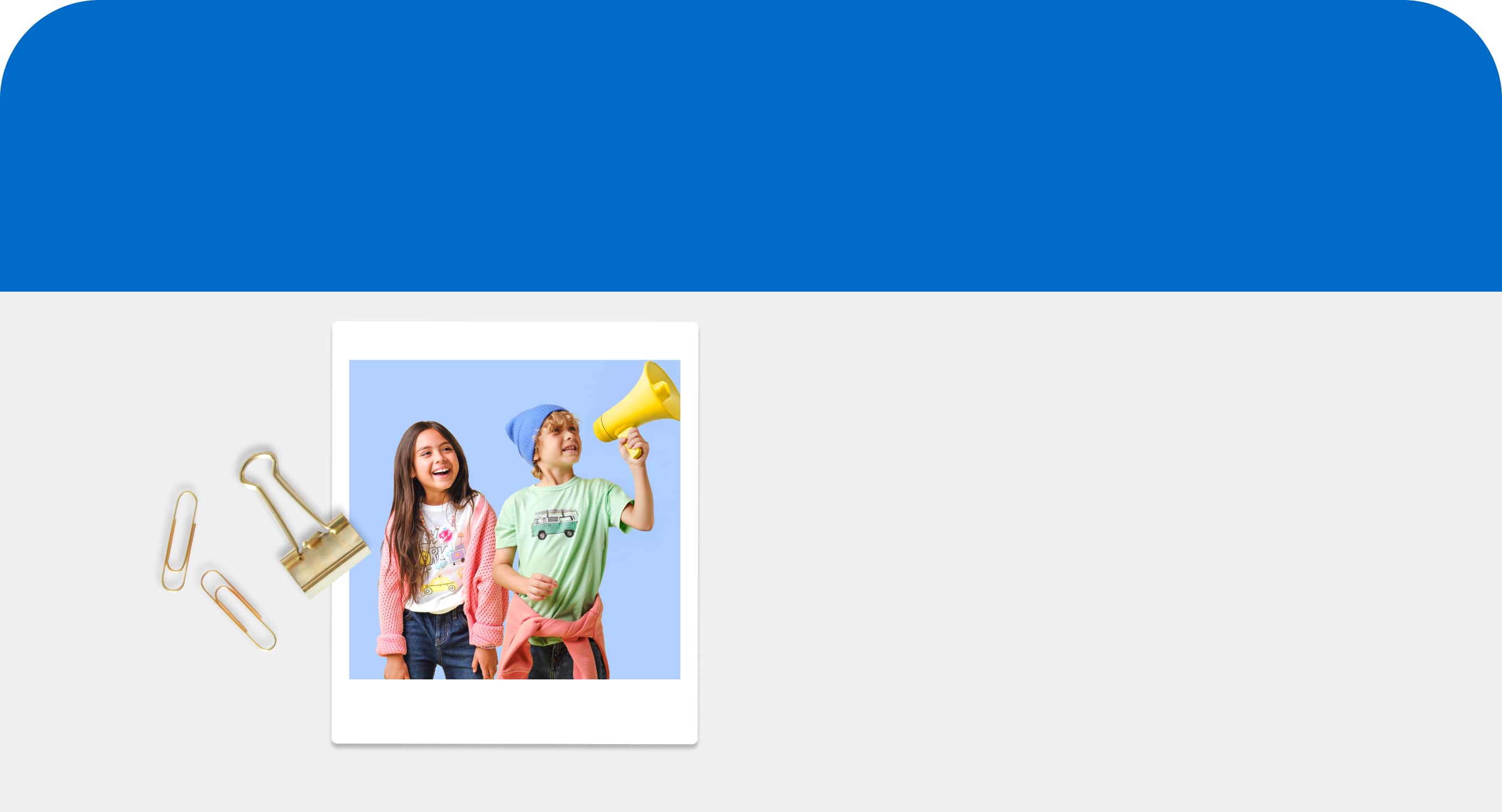 Two young kids in colorful clothing with one of them holding a yellow megaphone